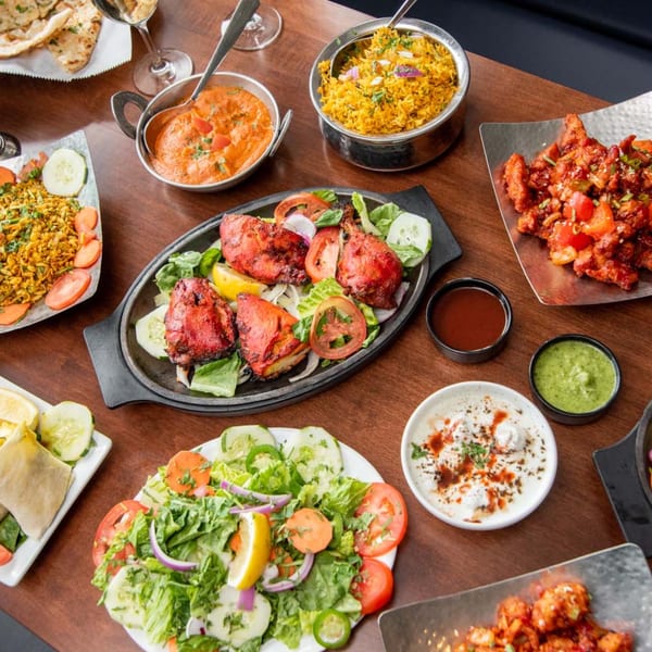 A feast of Indian dishes, including tandoori chicken, biryani, curries, and fresh salads.