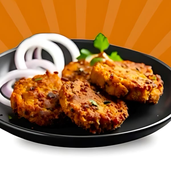 Tandoori Flame's Indian pakoras, garnished with fresh cilantro and white onion rings on a black plate.