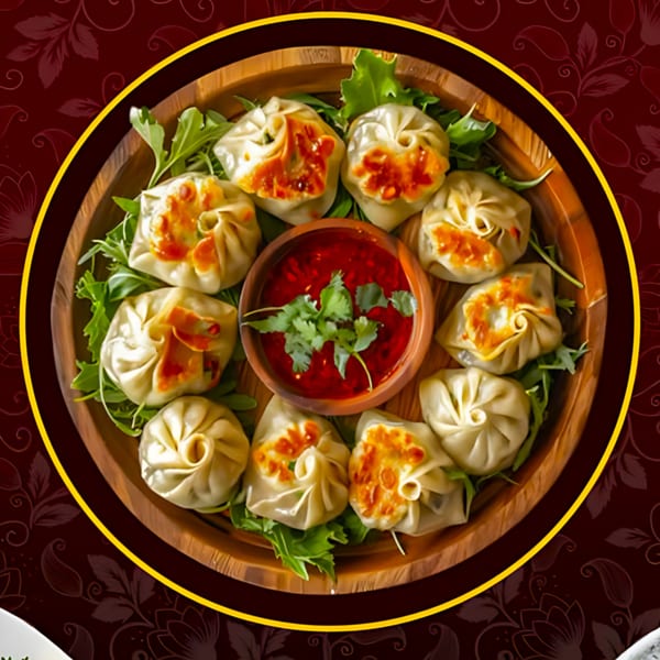A wooden platter of Tandoori Flame momos with a red dipping sauce and fresh greens.