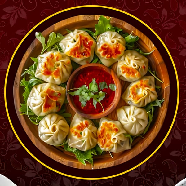 A wooden plate of Tandoori Flame momos with red dipping sauce and fresh cilantro.